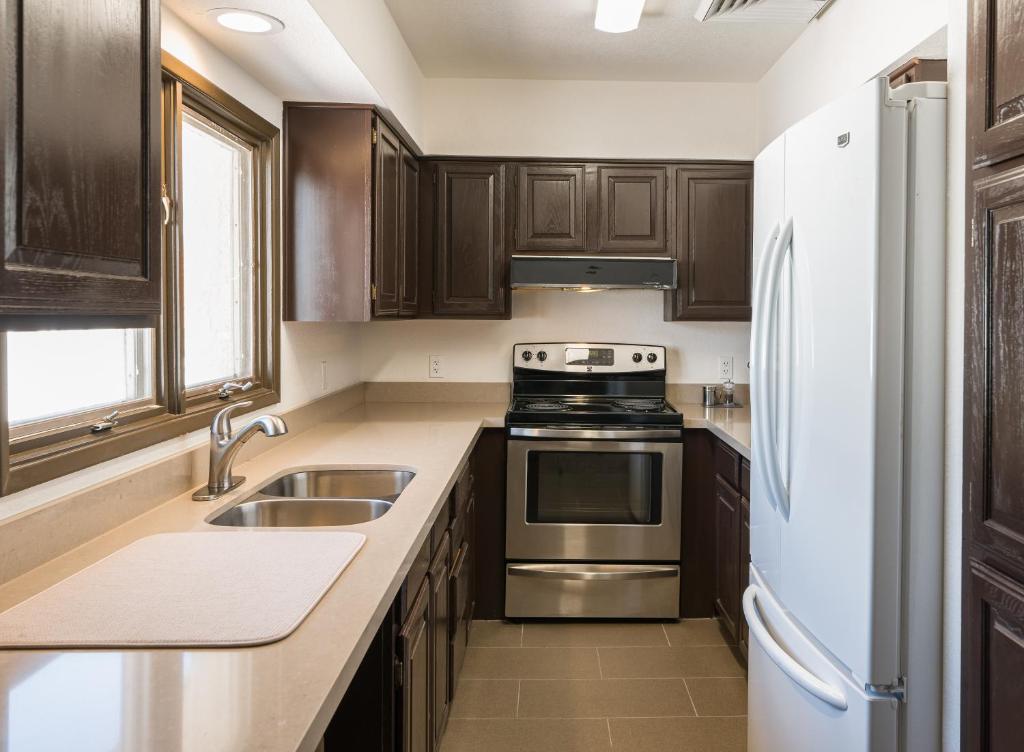a kitchen with wooden cabinets and stainless steel appliances at Lux Verde Hotel in Cottonwood