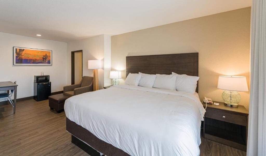 a hotel room with a large bed and a chair at Lux Verde Hotel in Cottonwood