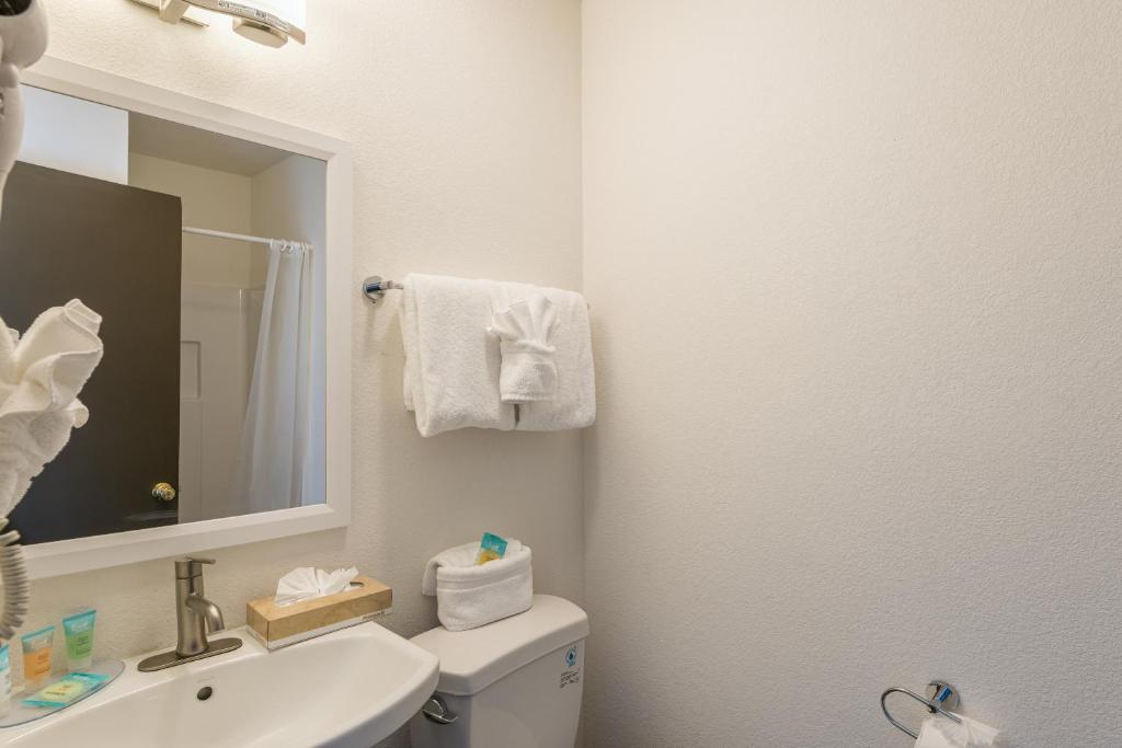 a white bathroom with a sink and a mirror at Lux Verde Hotel in Cottonwood