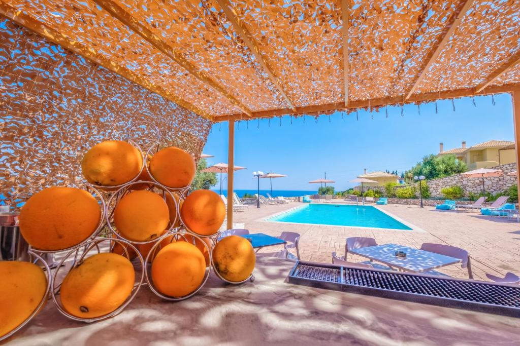 a container of oranges sitting next to a swimming pool at Hilltop Residences in Kalamaki