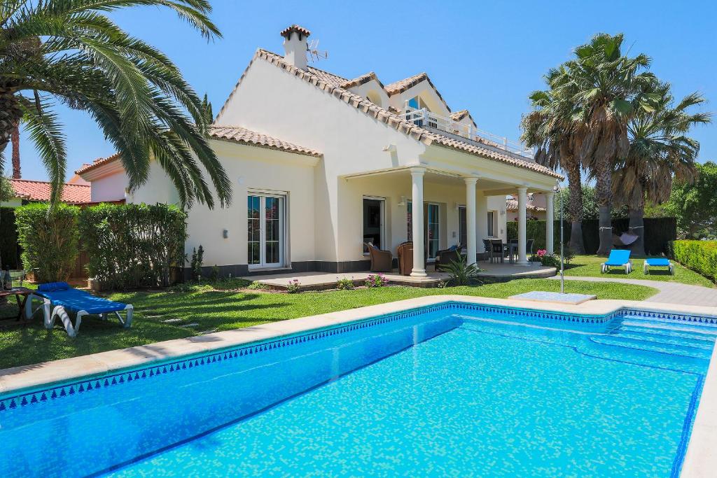 eine Villa mit einem Pool vor einem Haus in der Unterkunft Villa Lujo Olivanova Golf MET in Oliva