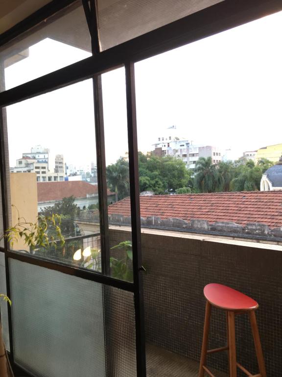 a view from a balcony with a red stool at Bom Retiro, literature & coffee in São Paulo