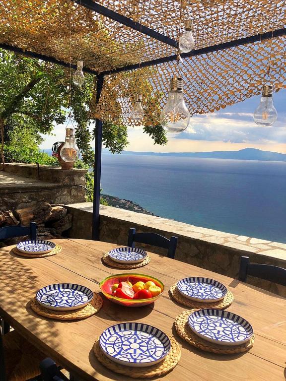 a wooden table with plates and bowls of fruit on it at The Villa of Blues in Kalamata