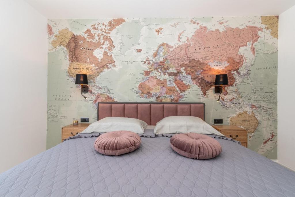 a bed with two pillows in front of a world map at Apartment Aron Trogir in Trogir