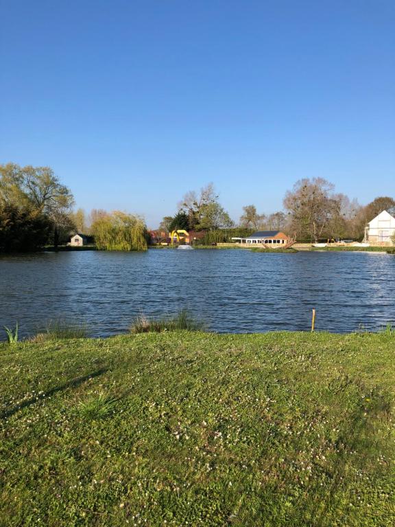 una vista de un río con un campo de hierba al lado en Le domaine de la carperie, en Bréhal