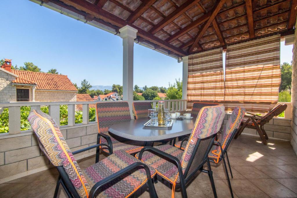 um pátio com uma mesa e cadeiras numa varanda em Apartments Jakov em Mirce