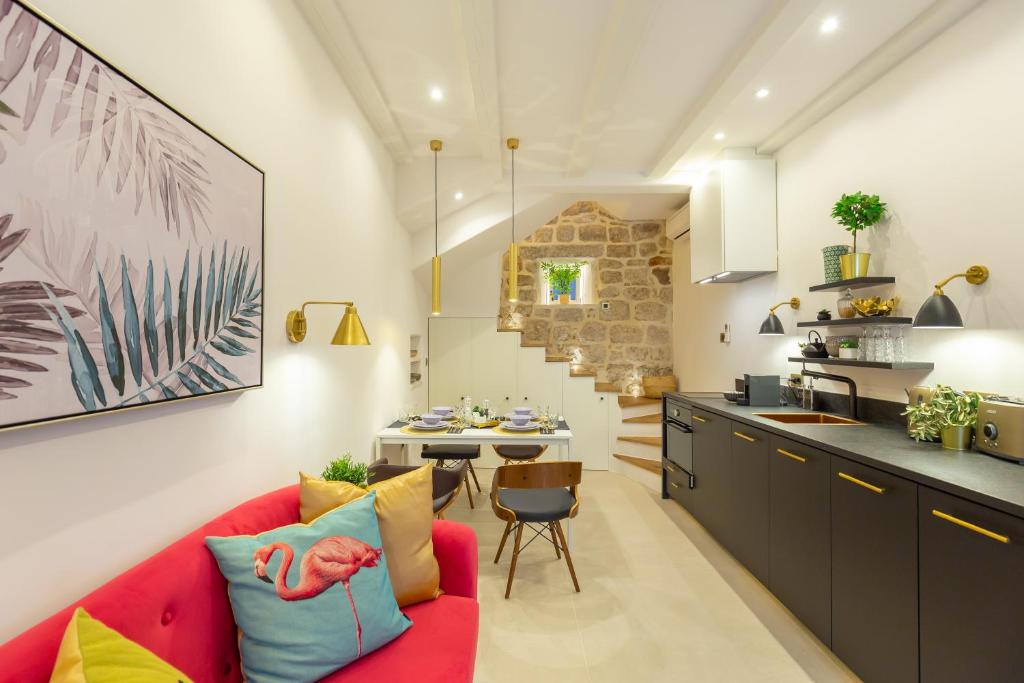 a kitchen and a living room with a red couch at Old Town House with Floor Heating & Lush Private Garden in Dubrovnik