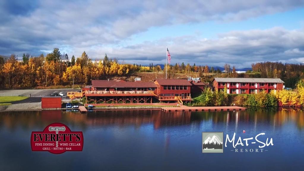 a large lodge on a lake with a building at Mat-Su Resort in Wasilla