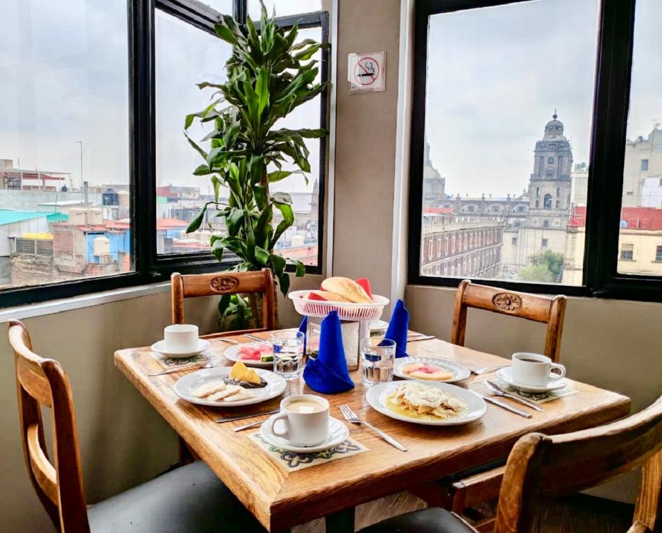a table with plates of food and a view of the city at Hotel Canada in Mexico City