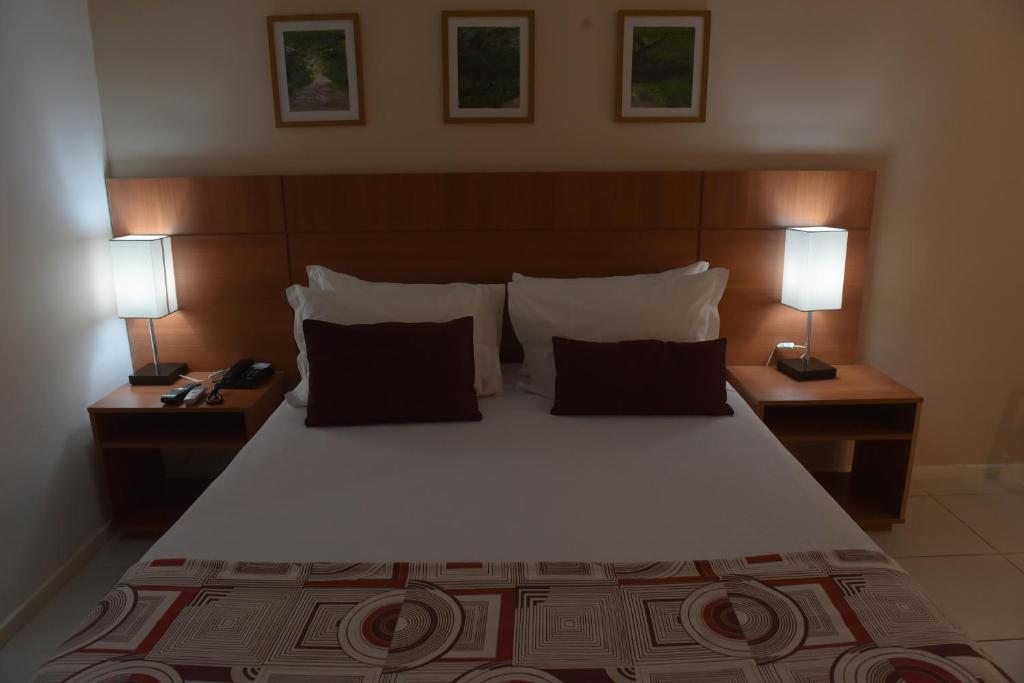 a bedroom with a large bed with two lamps at Best Hotel Sobral in Sobral