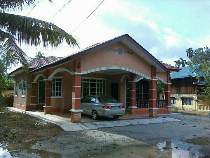 a small house with a car parked in front of it at Idaman homestay in Bukit Mertajam