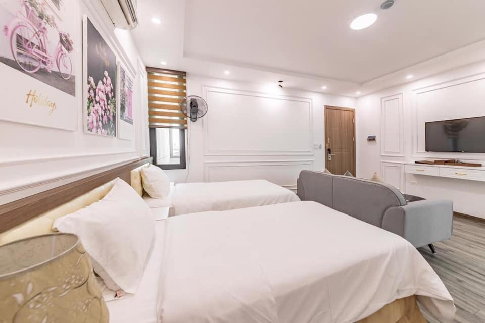 Habitación de hotel con 2 camas y TV en EVEREST HOTEL en Hanoi