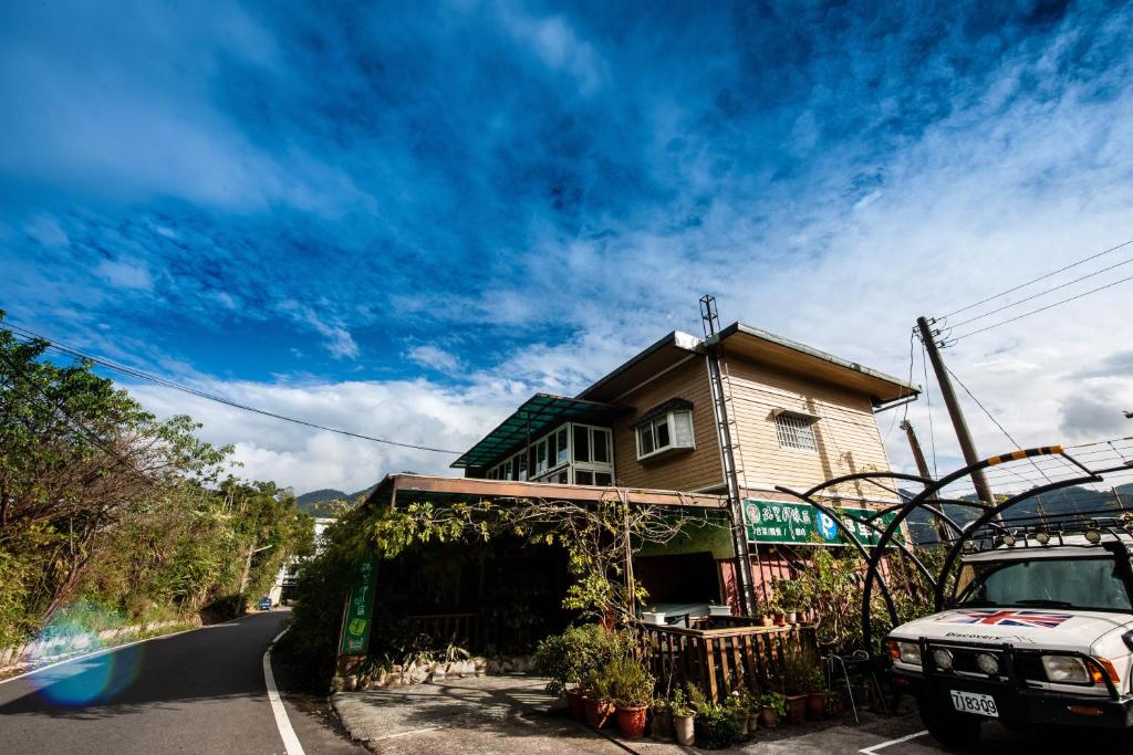 a house sitting on the side of a road at Rui Li Yinxiang Qu Homestay in Meishan