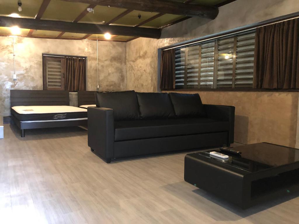 a living room with a black couch and a table at Villa Gazamani Aug,2019 Open!! For only one group a day in Yaese