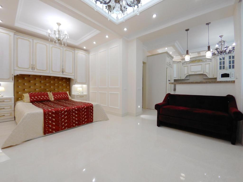 a large white bedroom with a bed and a couch at Квартира посуточно в Соломенском районе in Kyiv