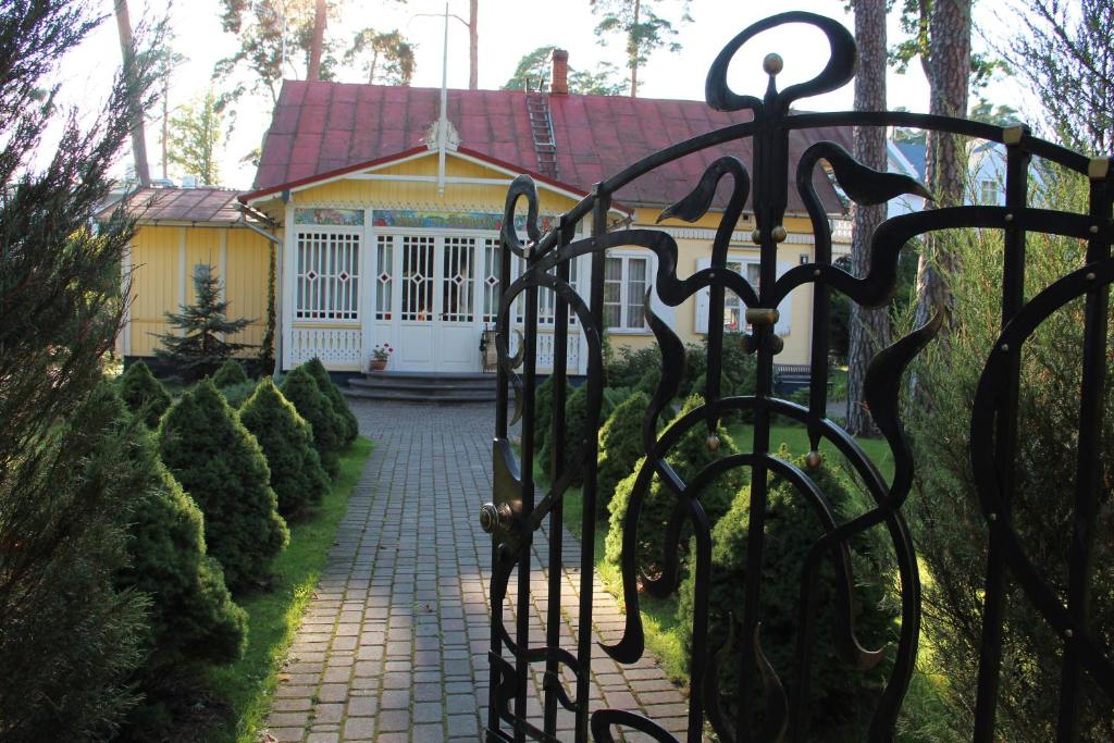 a gate in front of a house with a yellow house at Villa Florio in Jūrmala
