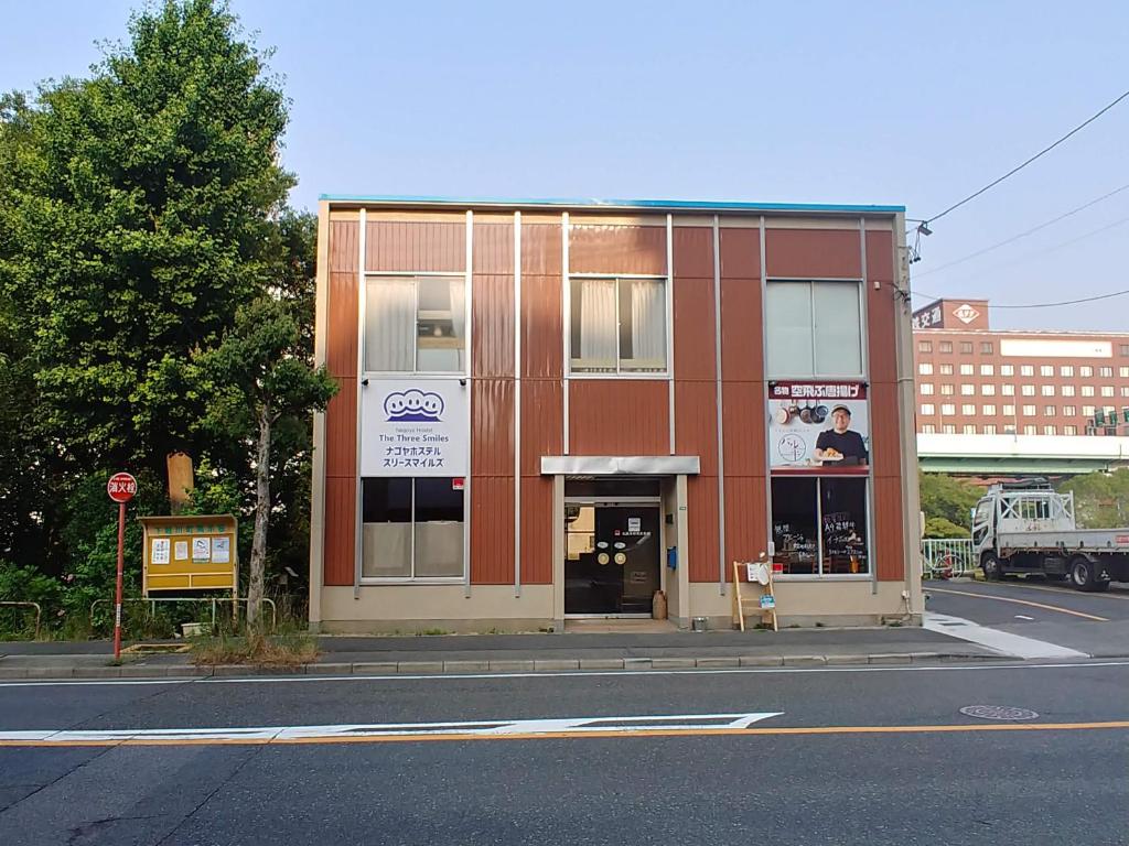 ein Gebäude an der Ecke einer Straße in der Unterkunft 駐車場無料 Nagoya Hostel The Three Smiles Free Car Park in Nagoya