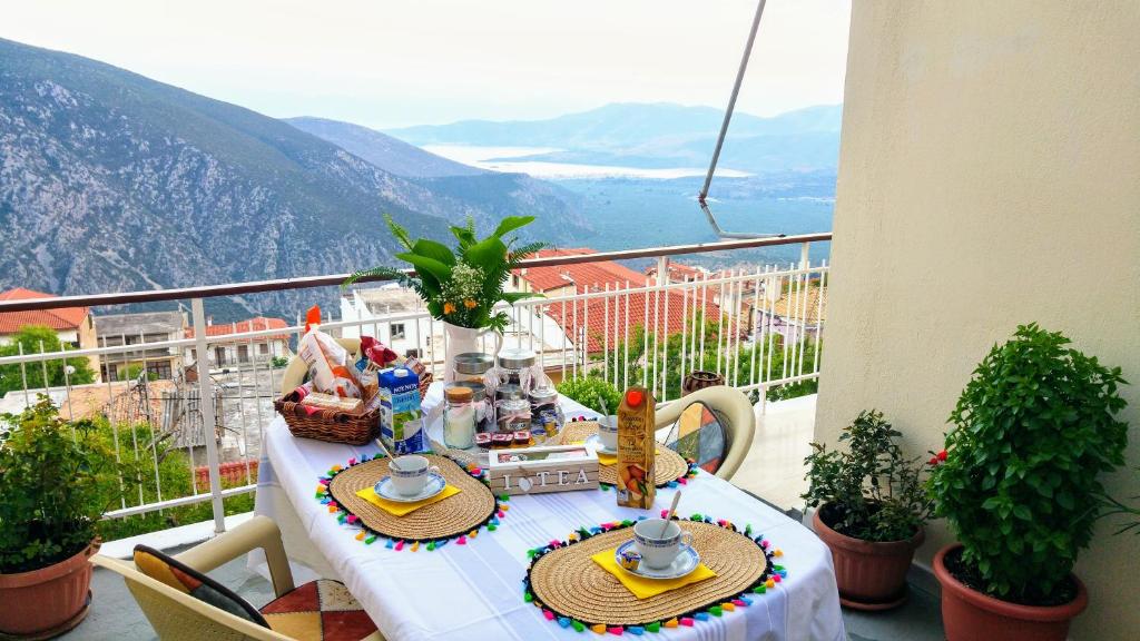 a table on a balcony with a view of mountains at Delphic Horizons in Delphi