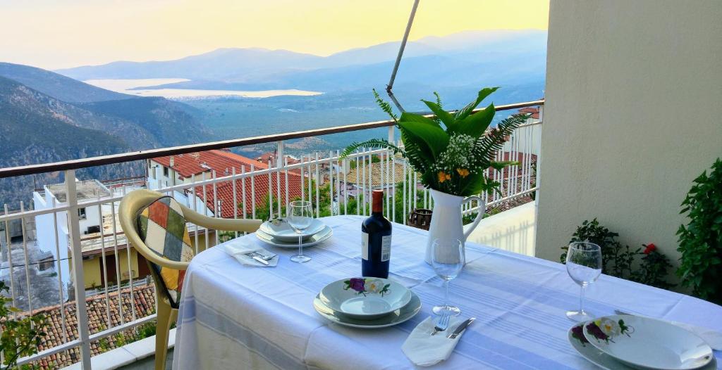a table with a bottle of wine on a balcony at Delphic Horizons in Delphi