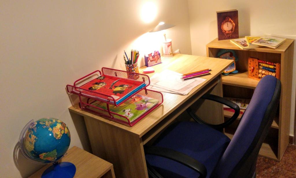 an office with a desk with a blue chair and a table with a globe at Delphic Horizons in Delphi