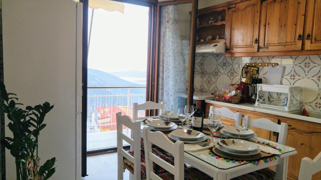 a kitchen with a table and chairs with a view of a balcony at Delphic Horizons in Delphi