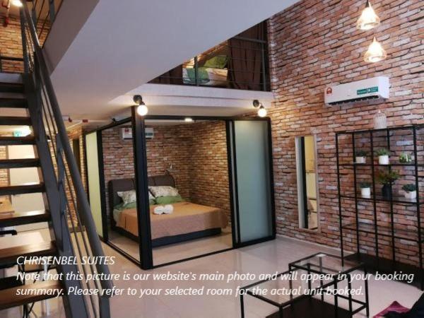 a room with a bed and a brick wall at Chrisenbel Suites - Pinnacle PJ in Petaling Jaya