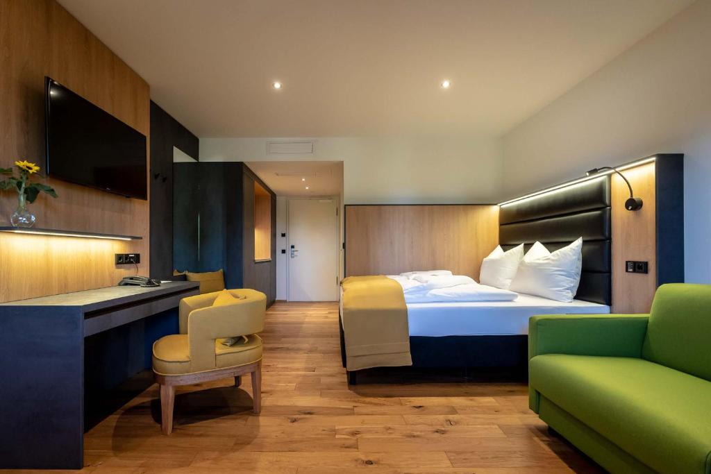 een hotelkamer met een bed en een bank bij Augsburg Hotel Sonnenhof in Gersthofen