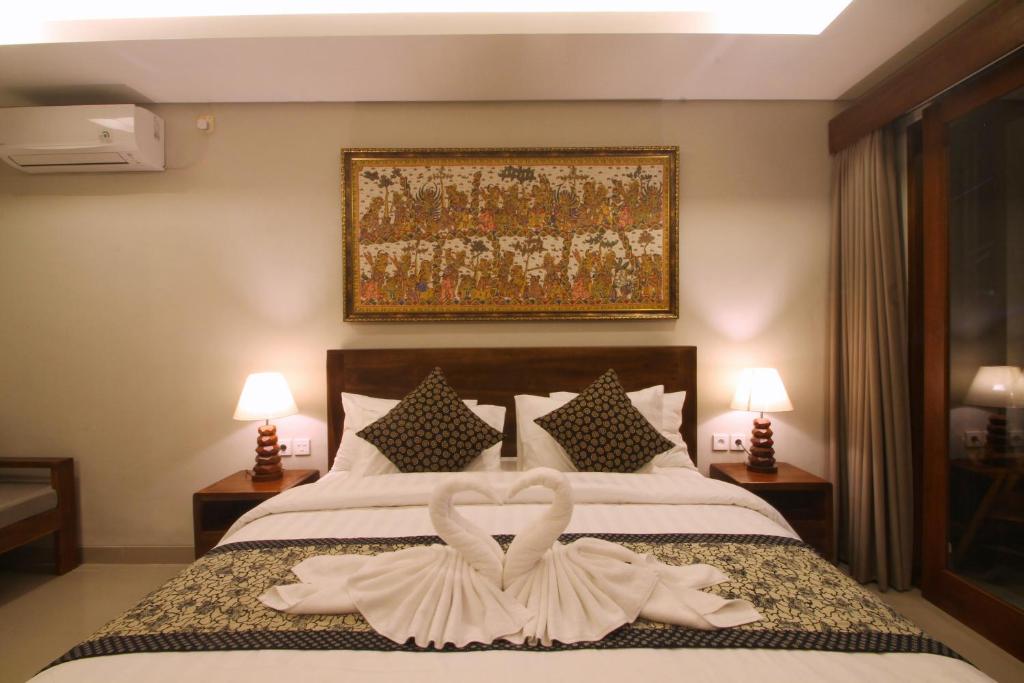 a bedroom with a bed with two swans made out of towels at The Kertha Ubud in Ubud