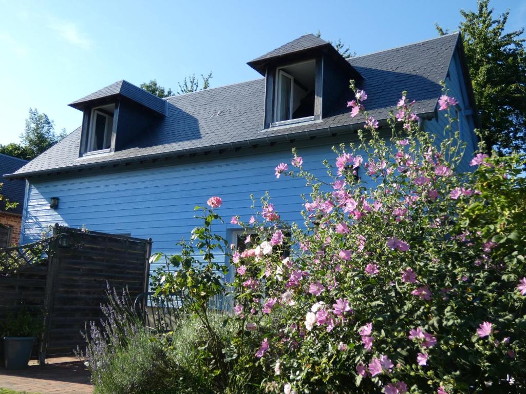ein blaues Haus mit Blumen davor in der Unterkunft Les Petits Matins Bleus - Chambres d'hôtes "Les Pommiers" in Sainte-Marguerite-de-Viette
