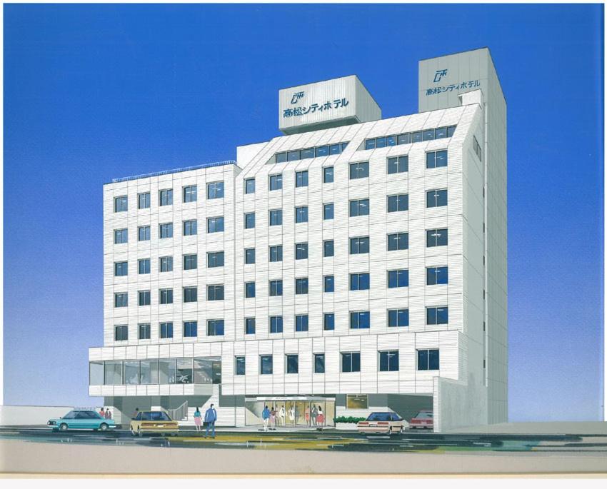 un edificio blanco con coches estacionados frente a él en Takamatsu City Hotel en Takamatsu