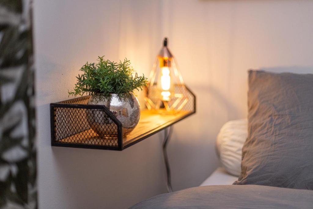 a table with a lamp on a wall next to a bed at Proche Paris, Confort, Wifi, Netflix in Deuil-la-Barre