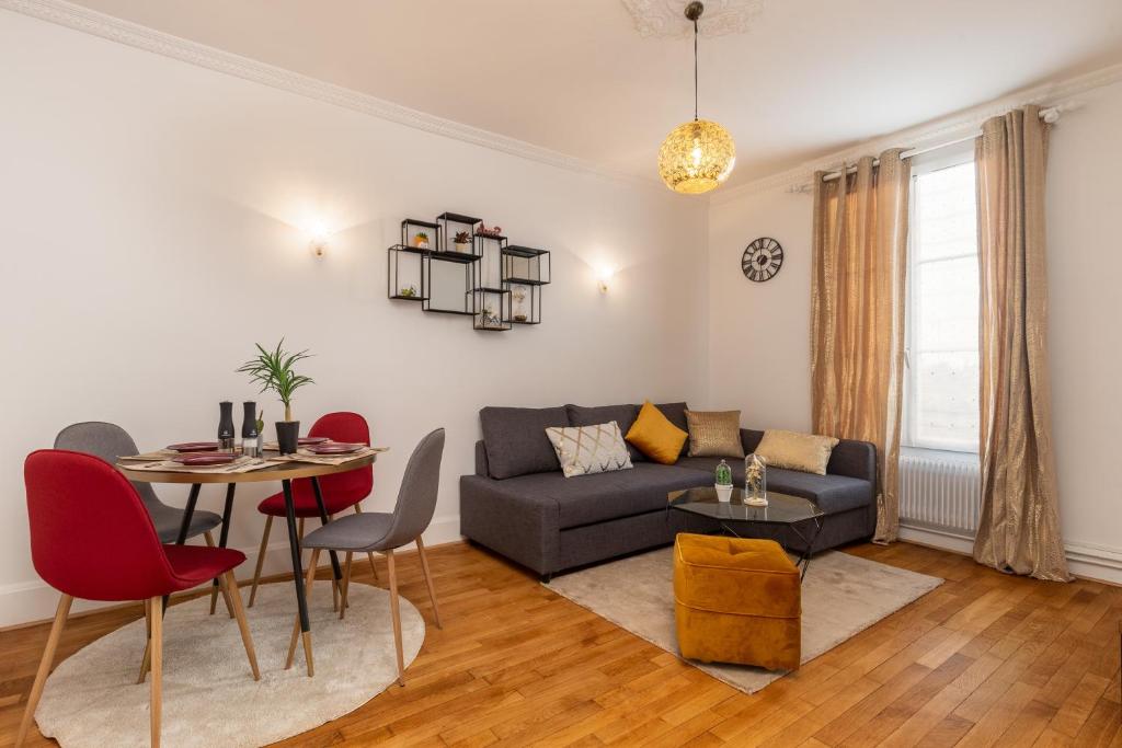 een woonkamer met een bank en een tafel bij Proche Paris, Confort, Wifi, Netflix in Deuil-la-Barre