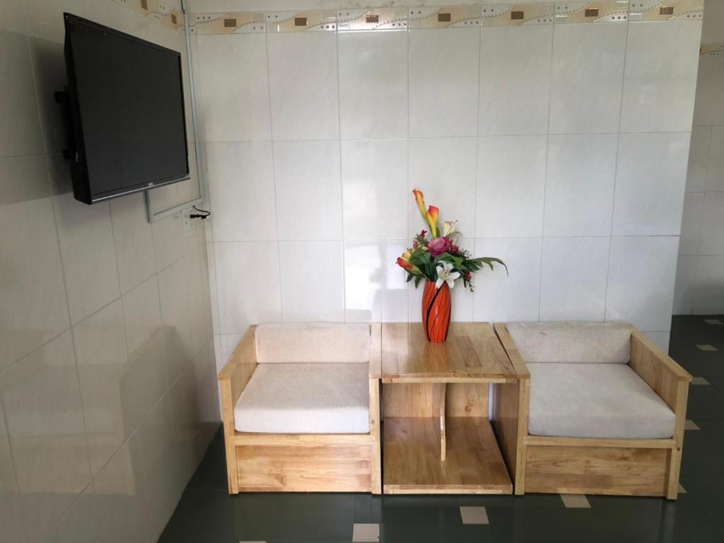 Zimmer mit einem Tisch und einer Vase aus Blumen in der Unterkunft Khách sạn Hương Mê in Buon Ma Thuot