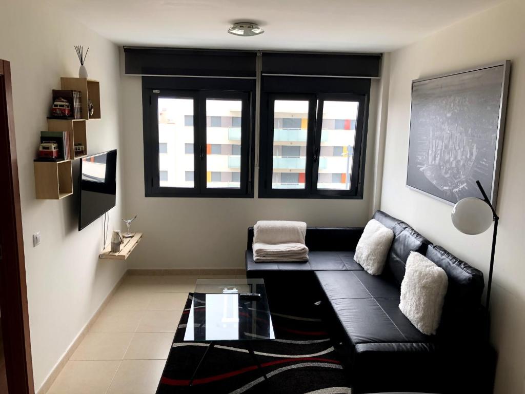 a living room with a black couch and a window at Apartamento en la Magalona in Icod de los Vinos