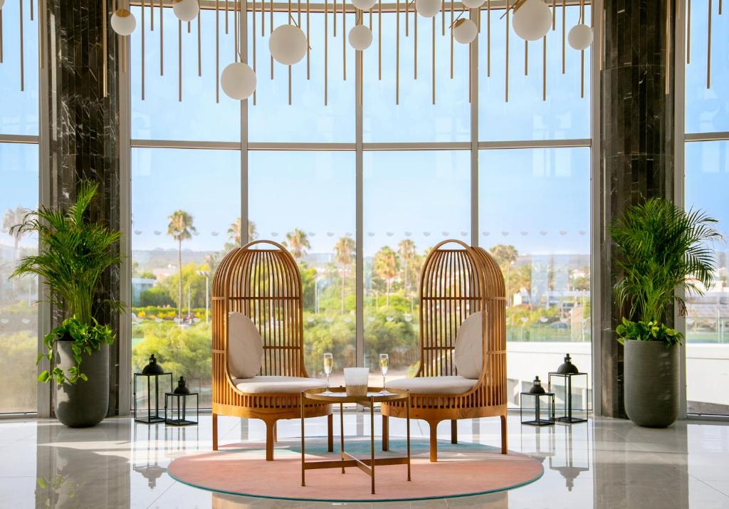 a dining room with two chairs and a table in front of a window at NissiBlu Beach Resort in Ayia Napa