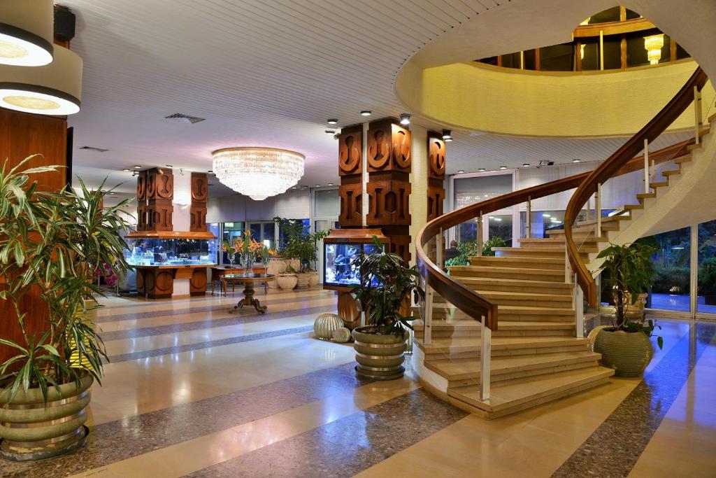 a lobby with stairs and potted plants in a mall at Carlton Madagascar in Antananarivo