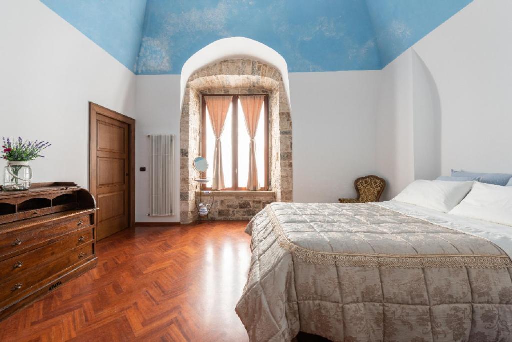 een slaapkamer met een groot bed en een raam bij Palazzo Morola XIV century in Giovinazzo