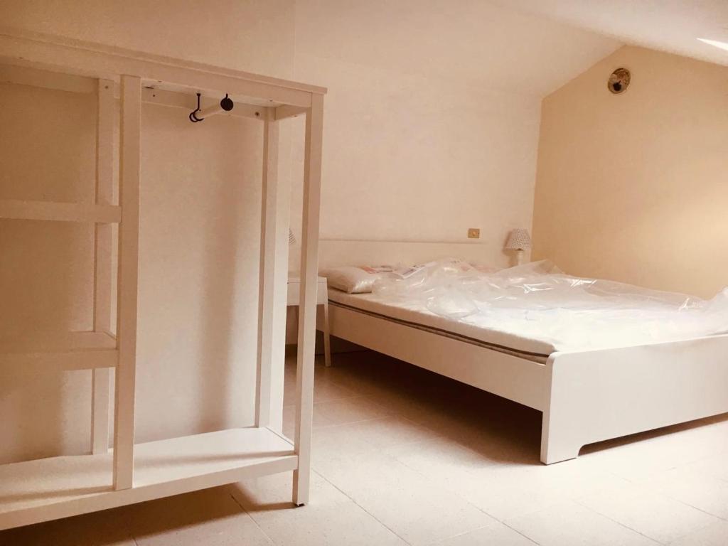 a bedroom with a white bed and a mirror at Mansardina in centro in Tagliacozzo