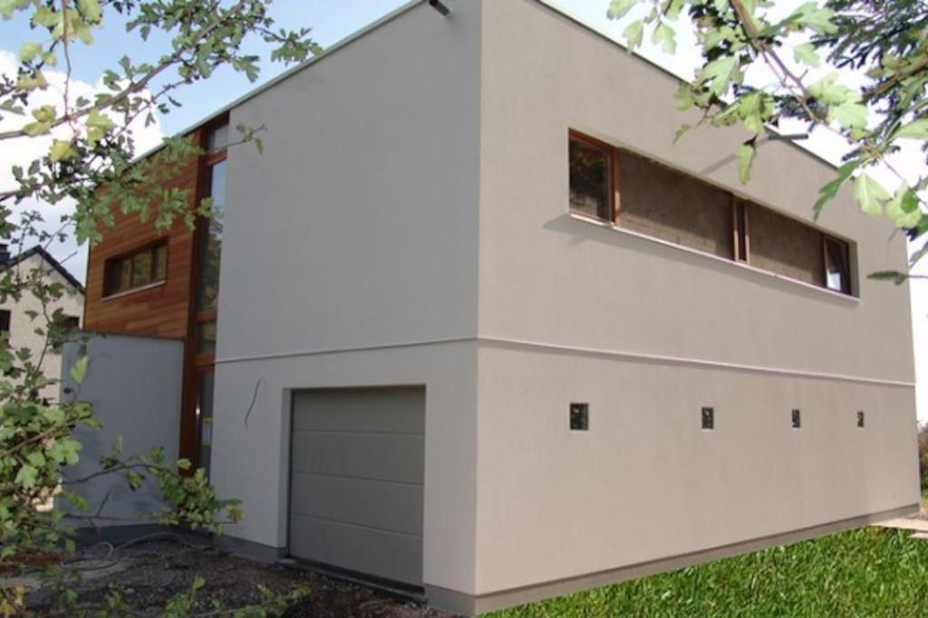 une maison blanche avec un garage dans l'établissement Maison contemporaine au Coeur des Ardennes Belges, à Stavelot