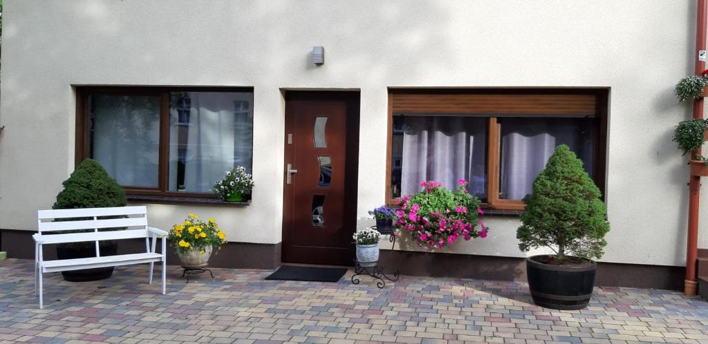 a house with a bench and flowers in front of it at Apartament wSPAniały. in Kowary