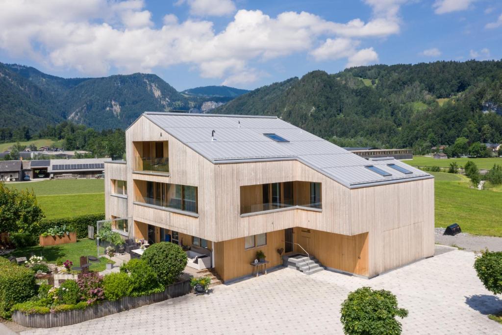an aerial view of a house with mountains in the background at Ferienwohnung Greber Gertraud in Bezau