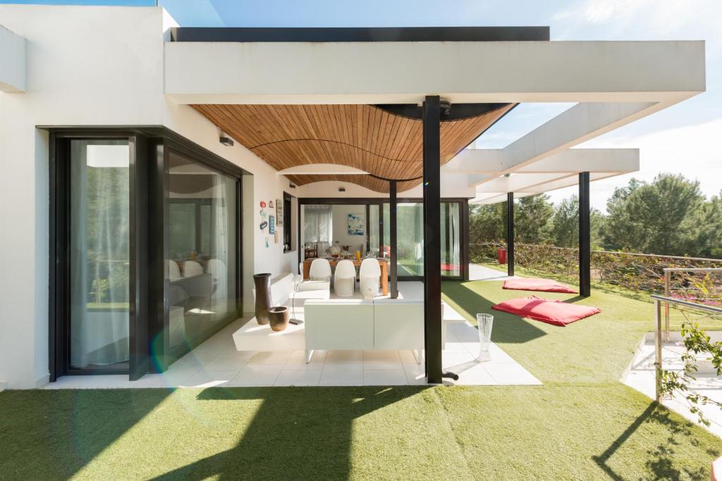 an open living room with glass doors and a table at Nyumba ya Sun in Cala Tarida