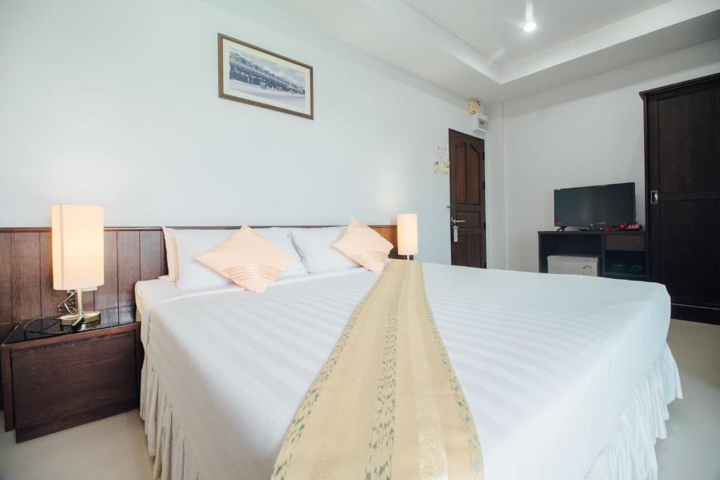 a bedroom with a large white bed with two pillows at Iyara Hua Hin Lodge in Hua Hin