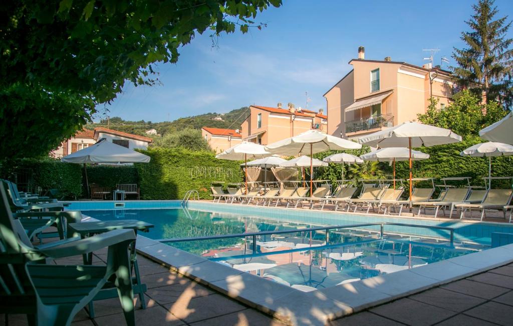 une grande piscine avec des chaises et des parasols dans l'établissement Residence Holidays, à Pietra Ligure