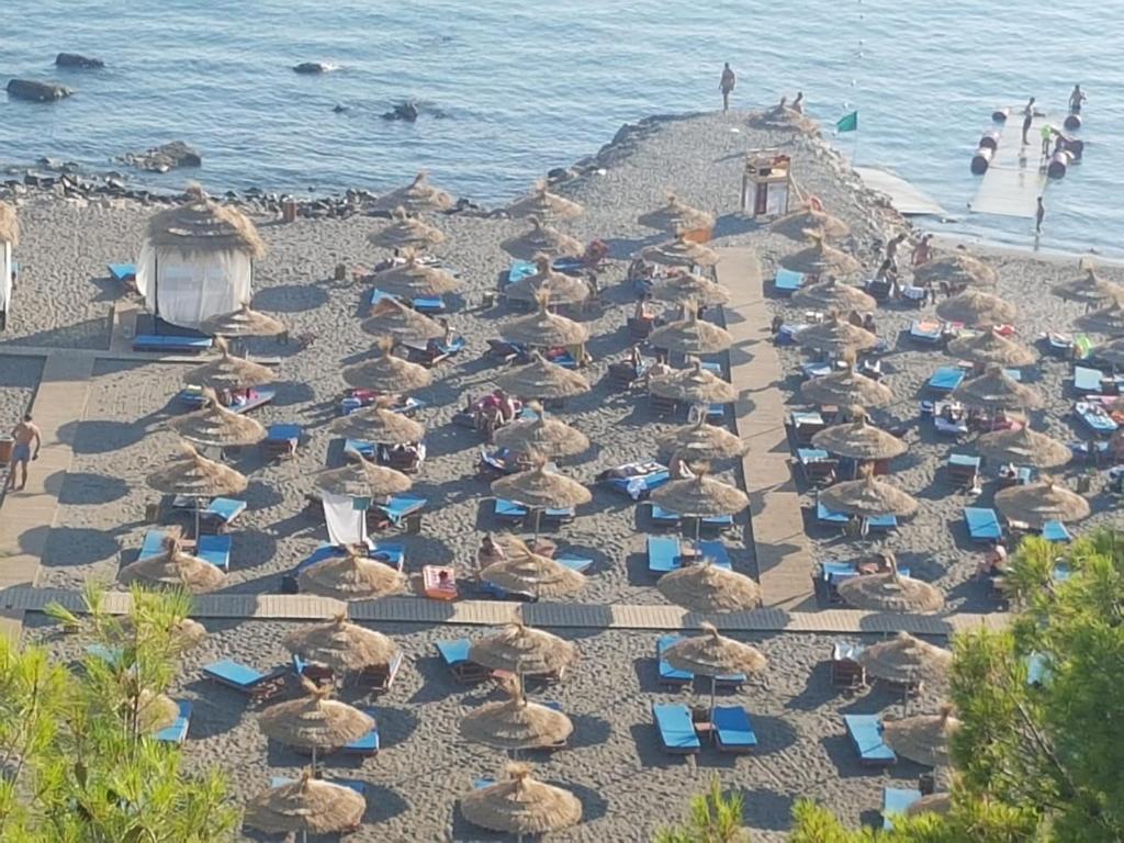 a group of chairs and umbrellas on a beach at Casa Del Mare Apartment in Shëngjin