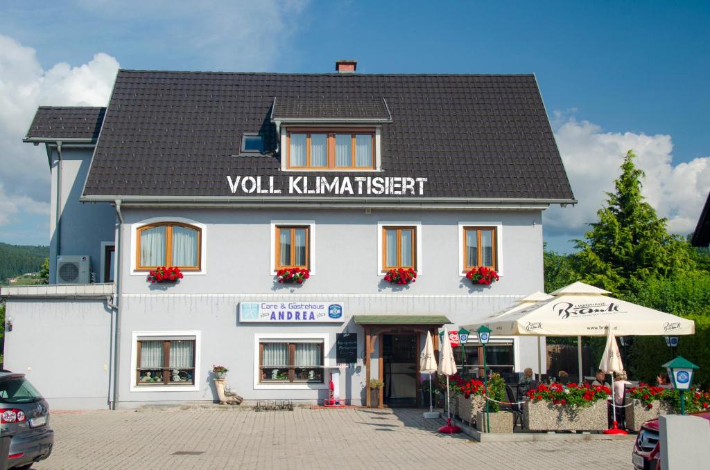 a white building with a black roof at Gästehaus Cafe Andrea in Köflach