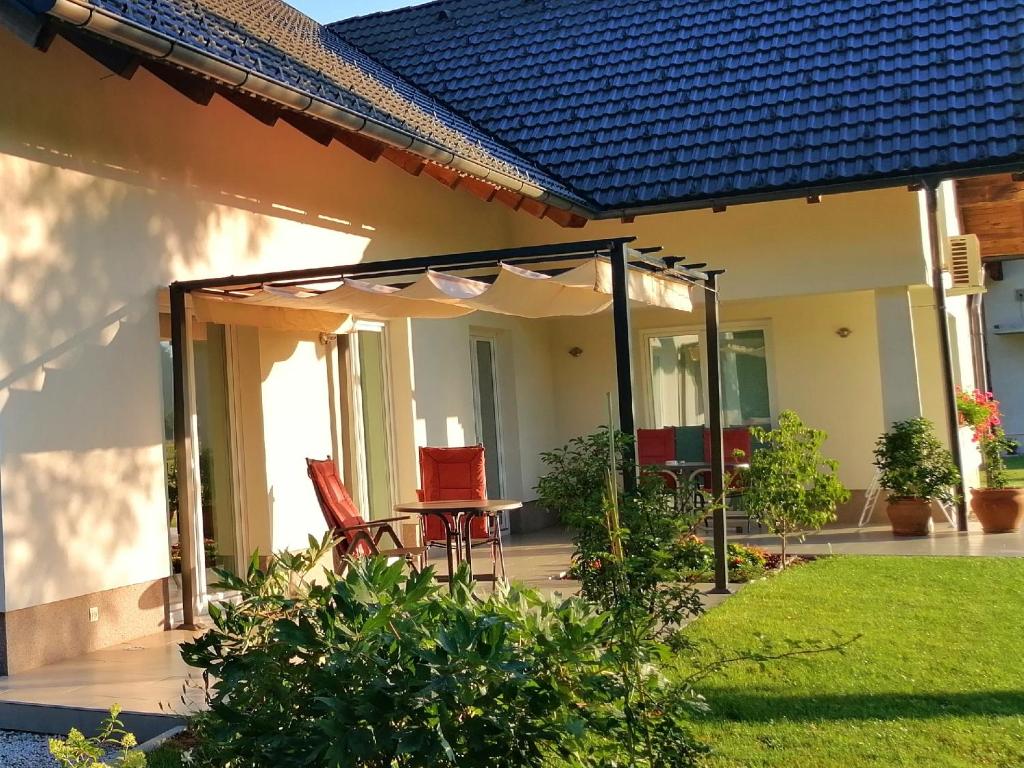 a patio with an umbrella and a table and chairs at Sobe Meta in Brezje