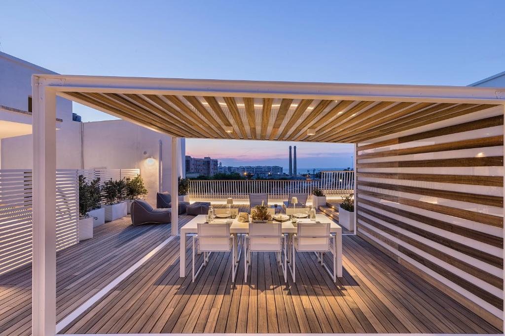 un patio avec une table et des chaises sur une terrasse dans l'établissement Attico sul Porto Antico, à Monopoli