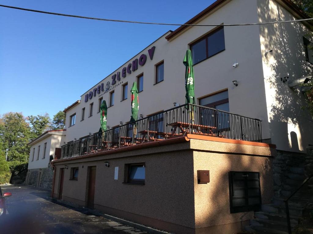 een gebouw met een balkon met vlaggen erop bij Hotel Zlechov in Plumlov