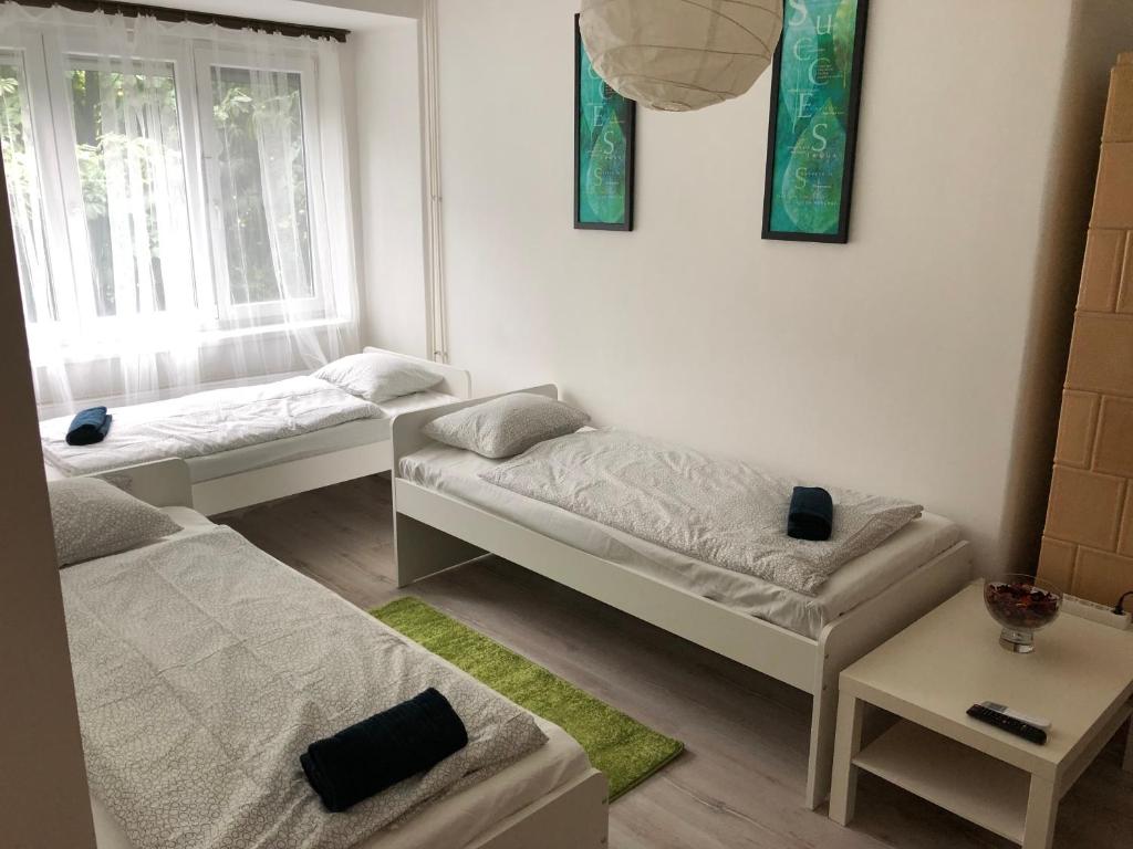 Habitación con 2 camas y mesa. en Sportarena & Stadion Apartman H-39, en Budapest